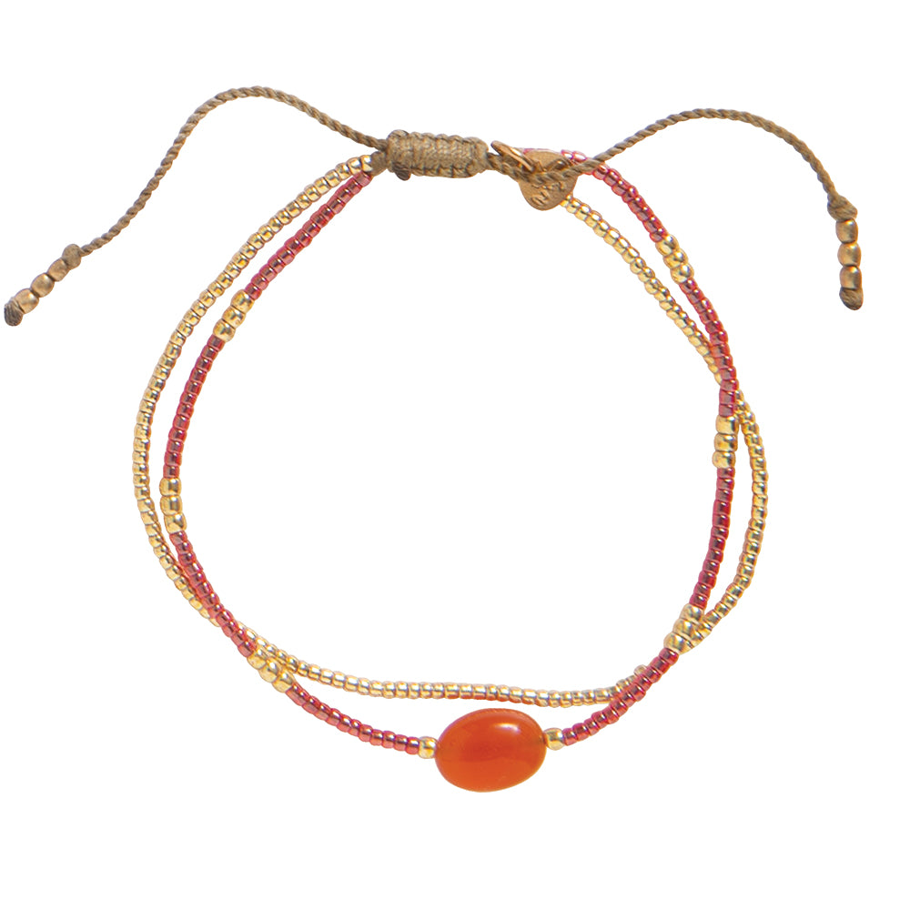 Dette lekre armbåndet fra A Beautiful Story kombinerer glassperler, messingperler og en stor karneol-edelstein. Takket være den justerbare glidende knuten kan armbåndets lengde tilpasses fra 16 til 22 centimeter.