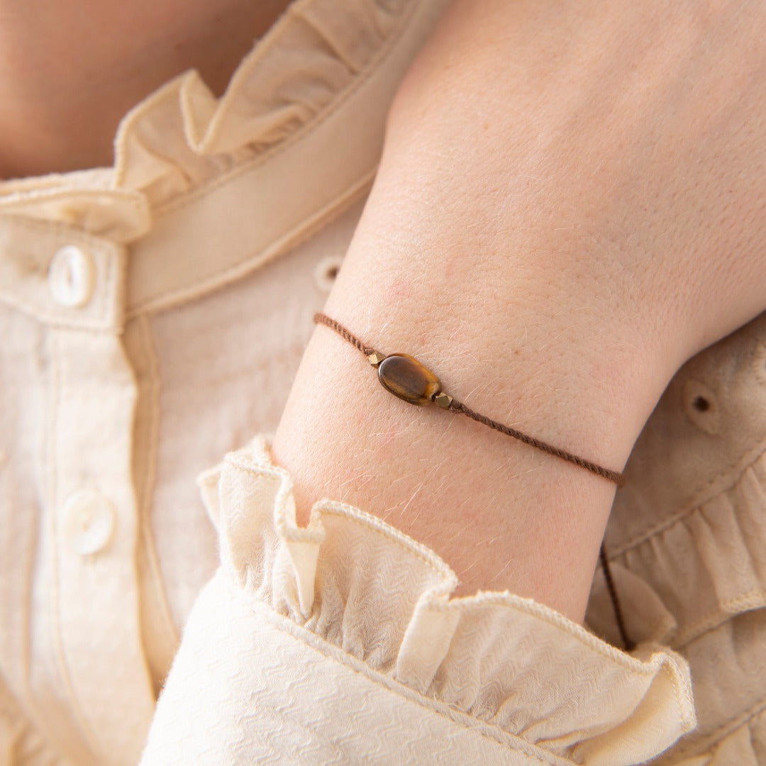 Tigerøye symboliserer takknemlighet, jording og intuisjon. Tigerøye Edelsten gir deg selvtillit. Dette armbandet er laget av bomullstråd og en Tigerøye edelsten. Lengden på armbandet er 15-22 cm. Armbåndet har en justerbar glideknute. Hver edelsten er unik. Det er derfor farger kan avvike fra bildene.