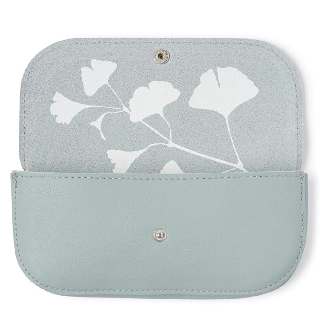 Dette stilige brilleetuiet, i fargen Dusty Green er laget av 100 % høykvalitetslær som gir langvarig beskyttelse. Innsiden har et håndtrykket gingko-tre, som symboliserer lang levetid og håp. Alle Keecie-produkter har unike håndtrykte mønstre med vannbaserte fargestoffer. Mål: 16.5 cm x 8 cm x 2.5 cm