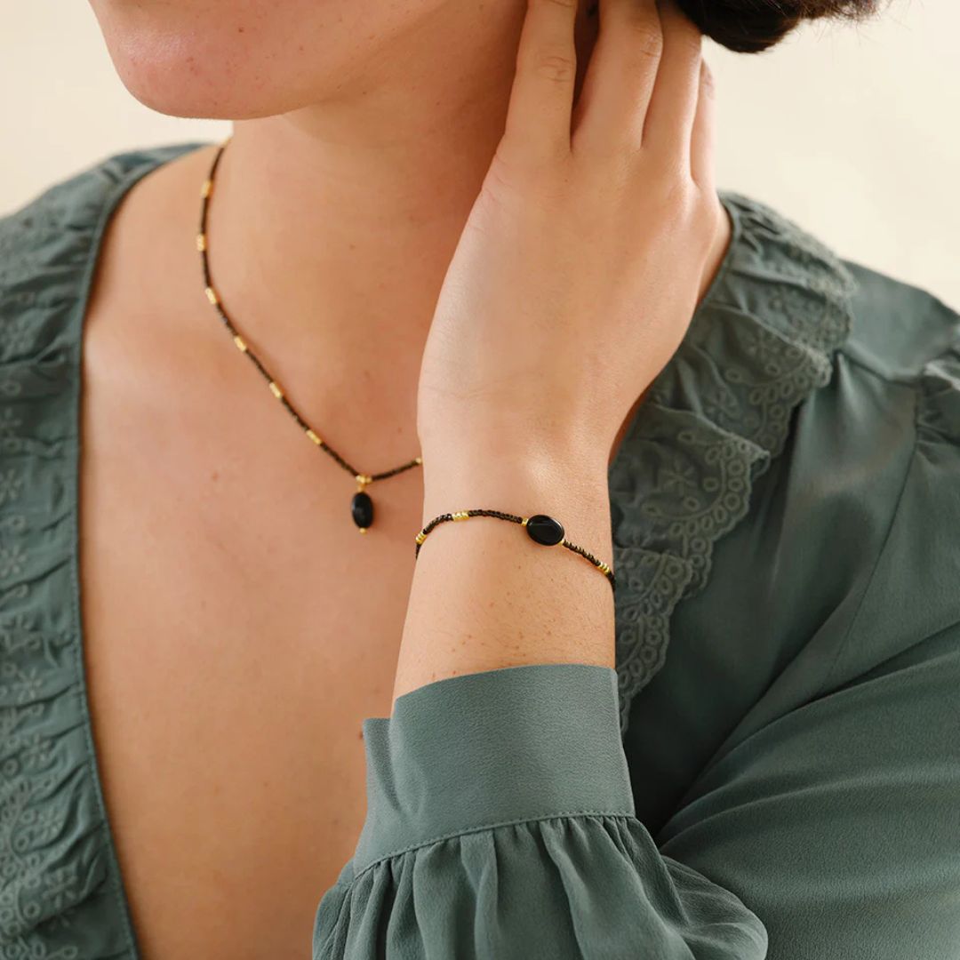 Onyksarmbånd med justerbar skyveknute, vist på håndledd.