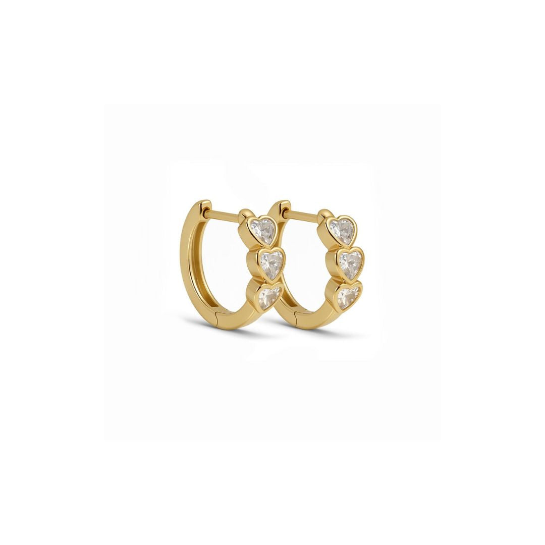 Små gullbelagte creoler med tre hjerter av zirkonia foran.
