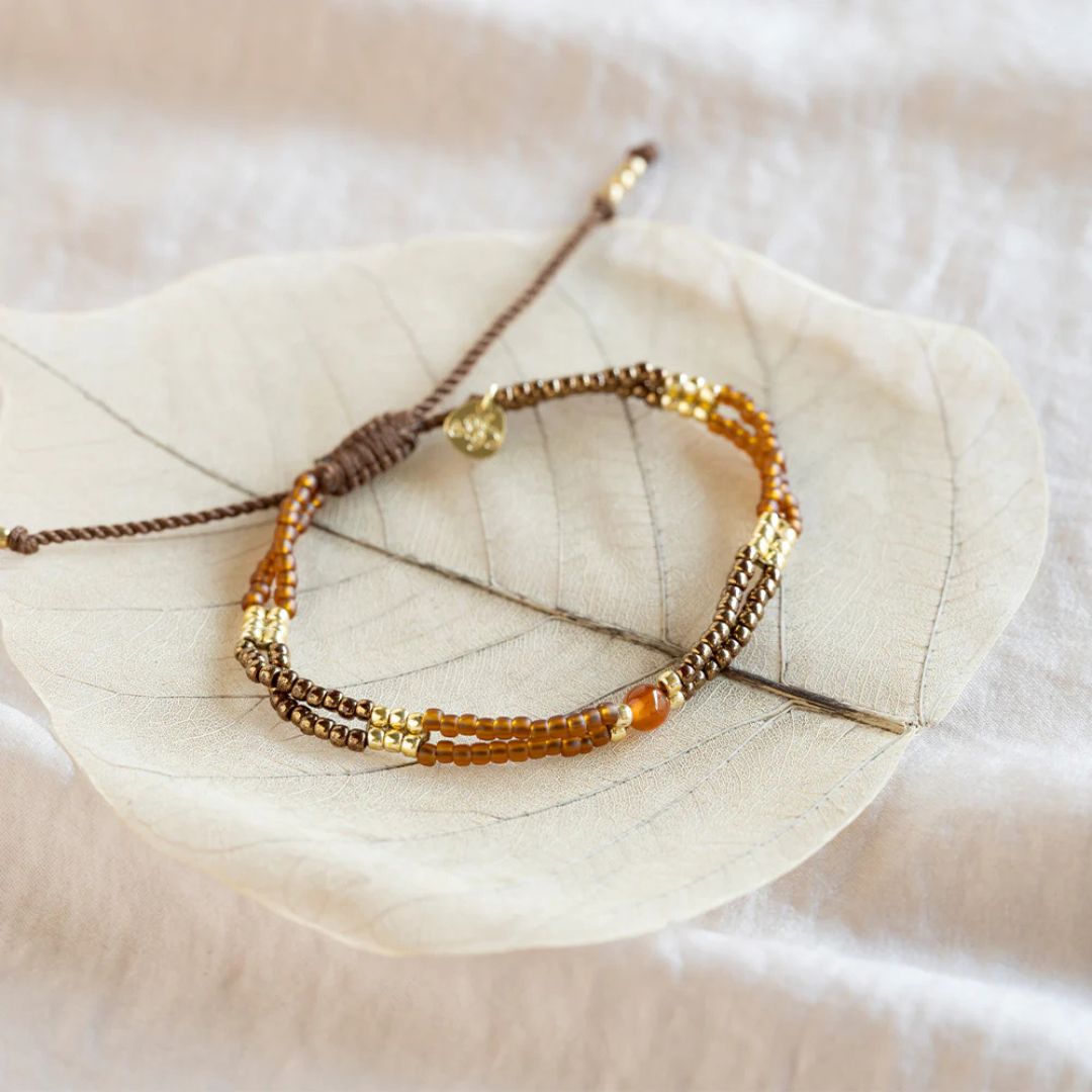 Compassionate Carnelian armbånd, fotografert på lyst blad