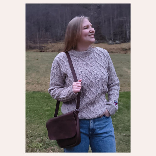 Jente med Norlender ullgenser Tórshavn i beige melert farge, ute i naturen.