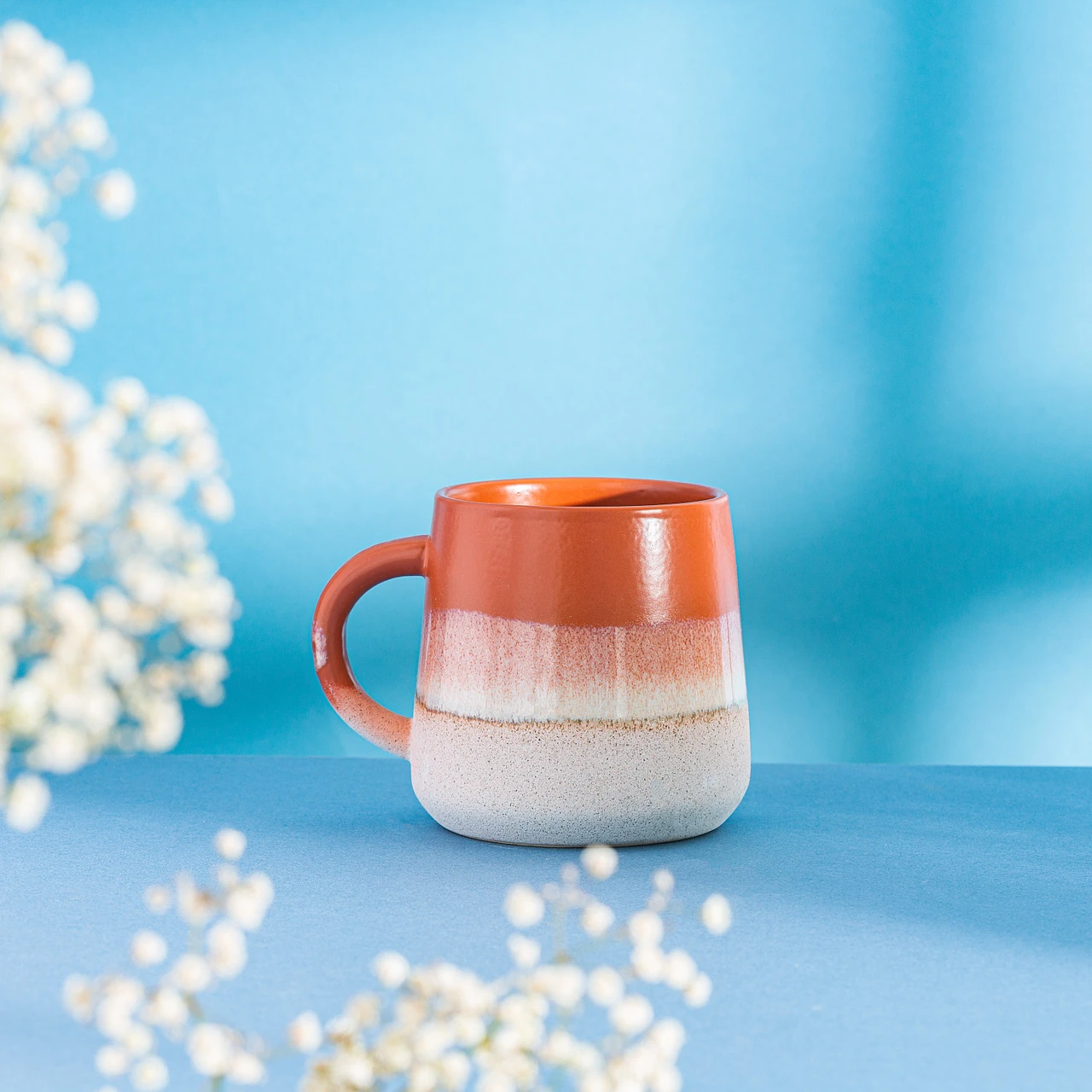 Sass & Belle Mojave Glaze brun kopp på blå bakgrunn